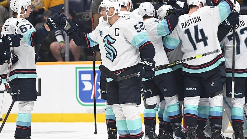 Oct 14, 2021; Nashville, Tennessee, USA; Seattle Kraken Seattle Kraken defenseman Mark Giordano (5) celebrates with teammates after the first win in franchise history following a win against the Nashville Predators at Bridgestone Arena. Mandatory Credit: Christopher Hanewinckel-USA TODAY Sports
