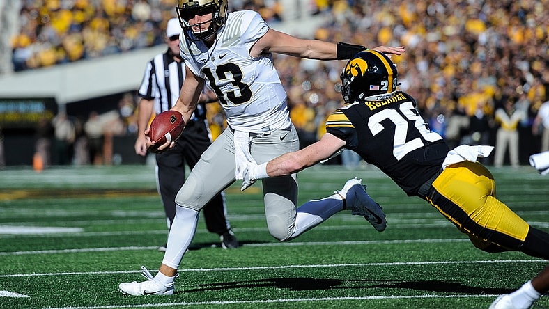 Oct 16, 2021; Iowa City, Iowa, USA; Purdue Boilermakers quarterback Jack Plummer (13) tries to avoid the tackle of Iowa Hawkeyes defensive back Jack Koerner (28) during the first quarter at Kinnick Stadium. Mandatory Credit: Jeffrey Becker-USA TODAY Sports