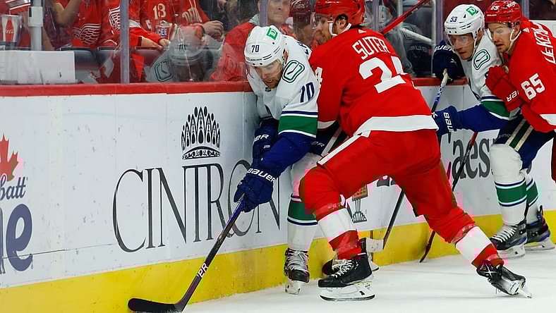 Oct 16, 2021; Detroit, Michigan, USA;  Vancouver Canucks left wing Tanner Pearson (70) is checked by Detroit Red Wings center Pius Suter (24) in the first period at Little Caesars Arena. Mandatory Credit: Rick Osentoski-USA TODAY Sports