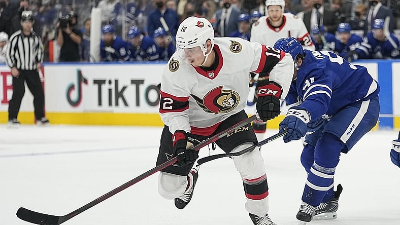 Oct 16, 2021; Toronto, Ontario, CAN; Ottawa Senators forward Shane Pinto (12) picks up a rebound against the Toronto Maple Leafs during the second period at Scotiabank Arena. Mandatory Credit: John E. Sokolowski-USA TODAY Sports