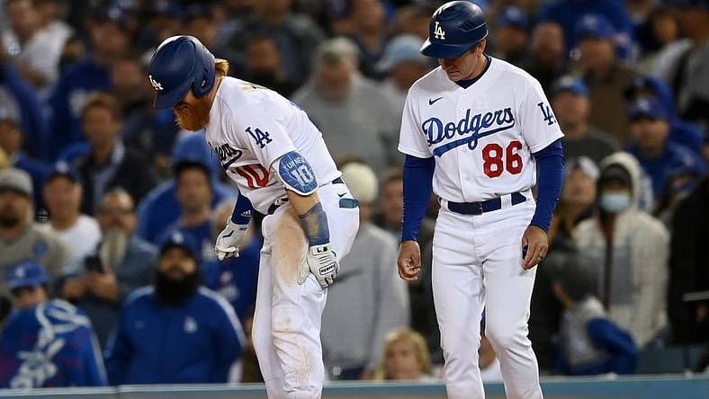 Oct 20, 2021; Los Angeles, California, USA; Los Angeles Dodgers third baseman Justin Turner (10) reacts with first base coach Clayton McCullough (86) after an injury in the seventh inning against the Atlanta Braves during game four of the 2021 NLCS at Dodger Stadium. Mandatory Credit: Jayne Kamin-Oncea-USA TODAY Sports