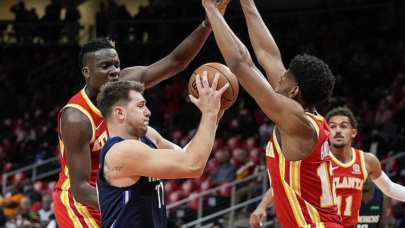 Oct 21, 2021; Atlanta, Georgia, USA; Dallas Mavericks guard Luka Doncic (77) is defended by Atlanta Hawks center Clint Capela (15) and forward De'Andre Hunter (12) during the first half at State Farm Arena. Mandatory Credit: Dale Zanine-USA TODAY Sports