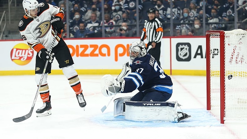 Oct 21, 2021; Winnipeg, Manitoba, CAN;  Anaheim Ducks forward Troy Terry (19) scores on Winnipeg Jets goalie Connor Hellebuyck (37) during the first period at Canada Life Centre. Mandatory Credit: Terrence Lee-USA TODAY Sports