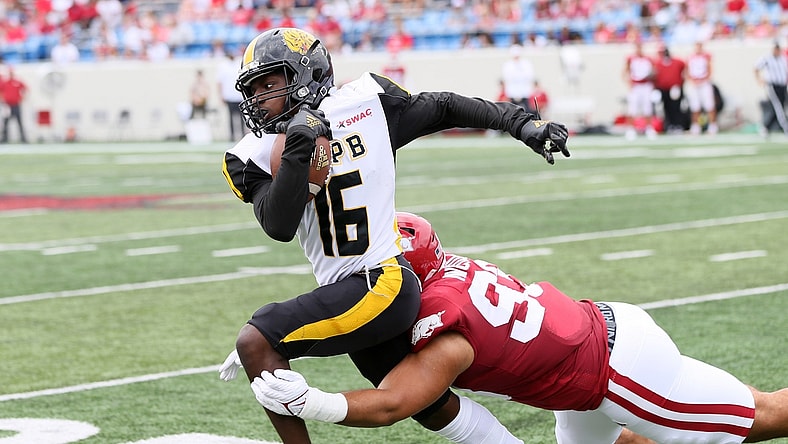 Oct 23, 2021; Little Rock, Arkansas, USA; Arkansas Pine Bluff Golden Lions wide receiver Dae'eion Dawkins (16) runs after a catch as Arkansas Razorbacks defensive lineman Isaiah Nichols (93) makes a tackle during the first quarter at War Memorial Stadium. Mandatory Credit: Nelson Chenault-USA TODAY Sports