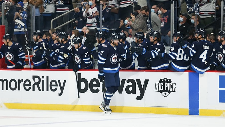 Oct 23, 2021; Winnipeg, Manitoba, CAN;  Winnipeg Jets forward Adam Lowry (17) is congratulated by his team mates on his goal against the Nashville Predators during the first period at Canada Life Centre. Mandatory Credit: Terrence Lee-USA TODAY Sports
