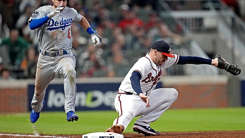 Oct 23, 2021; Cumberland, Georgia, USA; Atlanta Braves first baseman Freddie Freeman (5) makes a catch to force out Los Angeles Dodgers second baseman Trea Turner (6) during the sixth inning in game six of the 2021 NLCS at Truist Park. Mandatory Credit: Dale Zanine-USA TODAY Sports