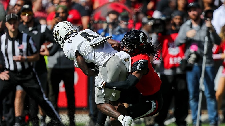 Oct 16, 2021; Cincinnati, Ohio, USA; Cincinnati Bearcats cornerback Arquon Bush (9) brings down UCF Knights wide receiver Ryan O'Keefe (4) in the first half at Nippert Stadium. Mandatory Credit: Katie Stratman-USA TODAY Sports
