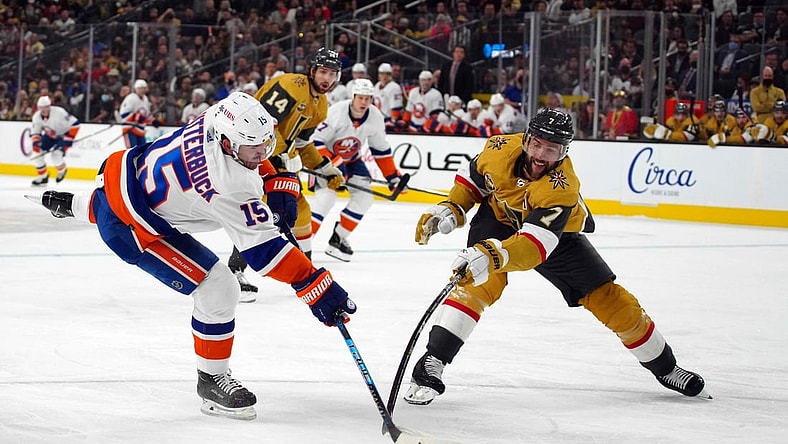 Oct 24, 2021; Las Vegas, Nevada, USA; New York Islanders right wing Cal Clutterbuck (15) and Vegas Golden Knights defenseman Alex Pietrangelo (7) reach for the puck in the first period at T-Mobile Arena. Mandatory Credit: Kirby Lee-USA TODAY Sports