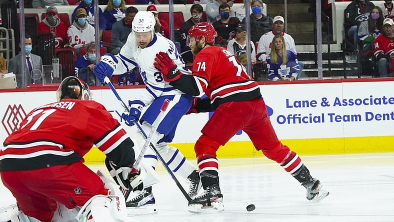 Oct 25, 2021; Raleigh, North Carolina, USA; Carolina Hurricanes defenseman Jaccob Slavin (74) defends against Toronto Maple Leafs center Auston Matthews (34) during the first period at PNC Arena. Mandatory Credit: James Guillory-USA TODAY Sports