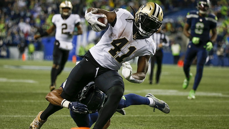 Oct 25, 2021; Seattle, Washington, USA; New Orleans Saints running back Alvin Kamara (41) breaks a tackle by Seattle Seahawks defensive back Ryan Neal (26) to score a touchdown on a reception during the second quarter at Lumen Field. Mandatory Credit: Joe Nicholson-USA TODAY Sports