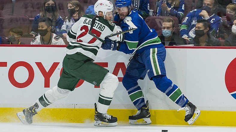 Oct 26, 2021; Vancouver, British Columbia, CAN; Minnesota Wild forward Nick Bjugstad (27) checks Vancouver Canucks forward J.T. Miller (9) in the first period at Rogers Arena. Mandatory Credit: Bob Frid-USA TODAY Sports