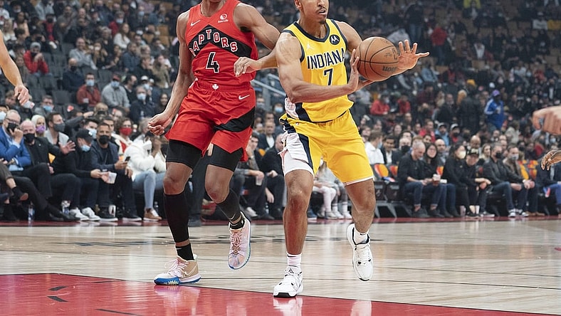 Oct 27, 2021; Toronto, Ontario, CAN; Indiana Pacers guard Malcolm Brogdon (7) controls the ball as Toronto Raptors forward Scottie Barnes (4) tries to defend during the first quarter at Scotiabank Arena. Mandatory Credit: Nick Turchiaro-USA TODAY Sports