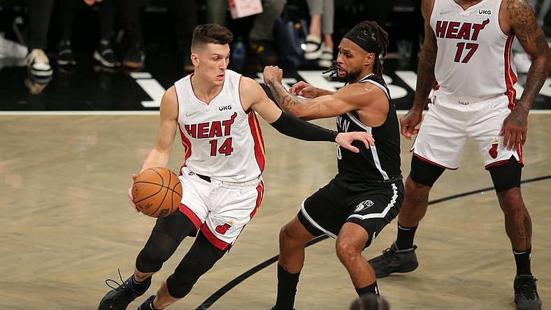 Oct 27, 2021; Brooklyn, New York, USA; Miami Heat guard Tyler Herro (14) controls the ball against Brooklyn Nets guard Patty Mills (8) during the first quarter at Barclays Center. Mandatory Credit: Brad Penner-USA TODAY Sports