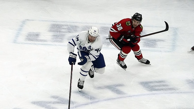 Oct 27, 2021; Chicago, Illinois, USA; Toronto Maple Leafs defenseman Morgan Rielly (44) is defended by Chicago Blackhawks left wing Brandon Hagel (38) during the first period at United Center. Mandatory Credit: David Banks-USA TODAY Sports