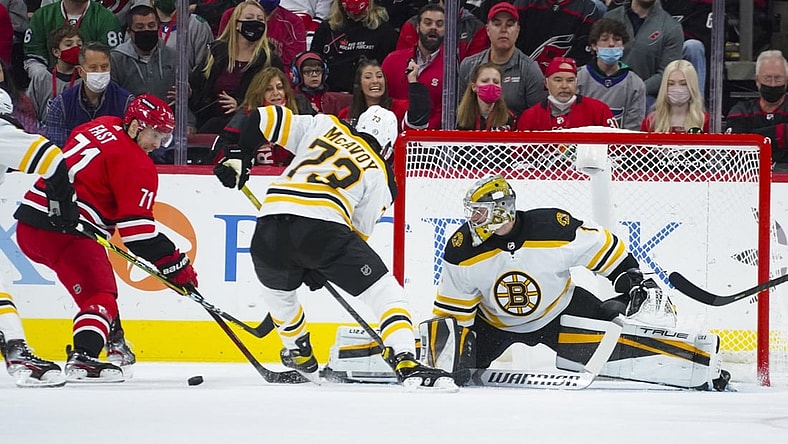Oct 28, 2021; Raleigh, North Carolina, USA; Boston Bruins goaltender Jeremy Swayman (1) and defenseman Charlie McAvoy (73) stop the scoring attempt by Carolina Hurricanes defenseman Tony DeAngelo (77) during the first period at PNC Arena. Mandatory Credit: James Guillory-USA TODAY Sports
