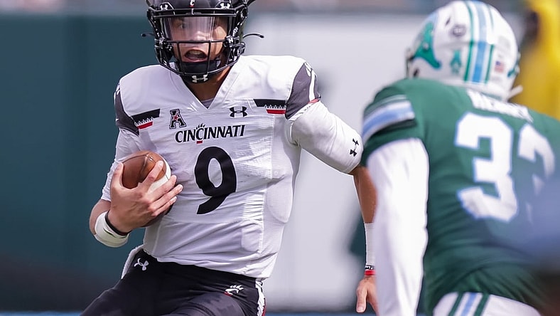Oct 30, 2021; New Orleans, Louisiana, USA;  Cincinnati Bearcats quarterback Desmond Ridder (9) runs against Tulane Green Wave linebacker Kevin Henry (33) during the first half at Yulman Stadium. Mandatory Credit: Stephen Lew-USA TODAY Sports