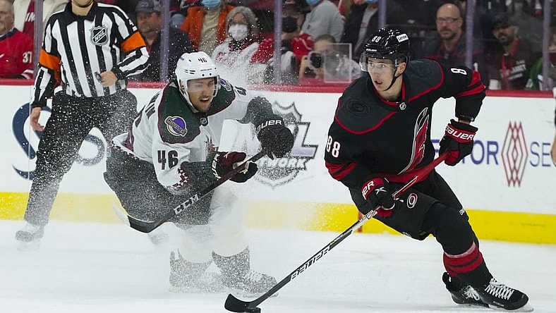 Oct 31, 2021; Raleigh, North Carolina, USA;  Carolina Hurricanes center Martin Necas (88) holds onto the puck next to Arizona Coyotes defenseman Ilya Lyubushkin (46) during the first period at PNC Arena. Mandatory Credit: James Guillory-USA TODAY Sports