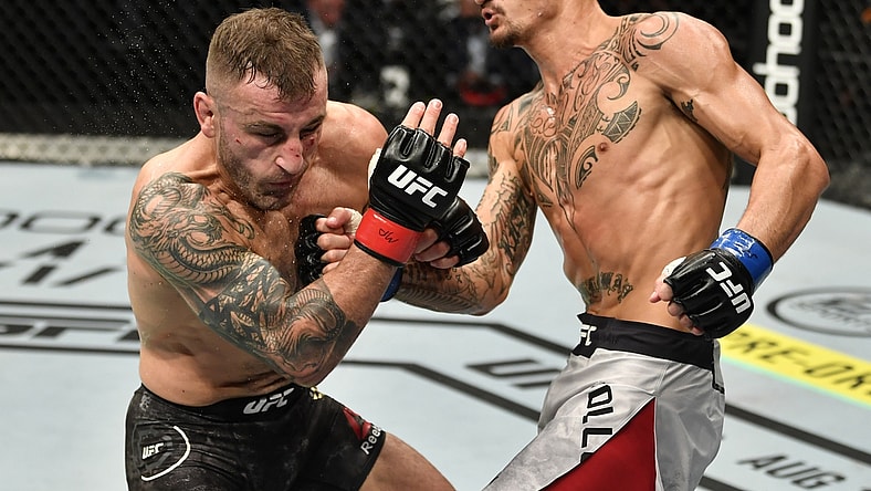 July 12, 2020; Abu Dhabi, UAE;  Max Holloway punches Alexander Volkanovski of Australia in their UFC featherweight championship fight during the UFC 251 event at Flash Forum on UFC Fight Island on July 12, 2020 on Yas Island, Abu Dhabi, United Arab Emirates.  Mandatory Credit: Jeff Bottari/Zuffa LLC via USA TODAY Sports