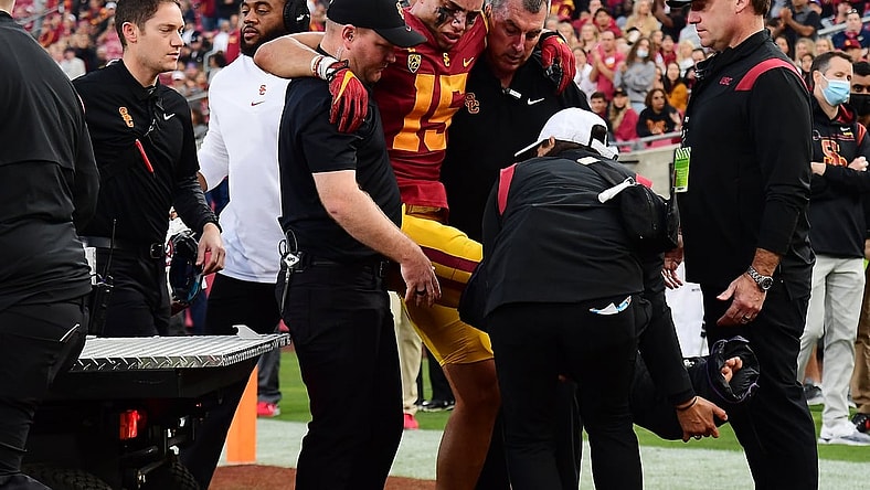 Oct 30, 2021; Los Angeles, California, USA; Southern California Trojans wide receiver Drake London (15) is helped off the field after suffering an injury against the Arizona Wildcats during the first half at United Airlines Field at Los Angeles Memorial Coliseum. Mandatory Credit: Gary A. Vasquez-USA TODAY Sports
