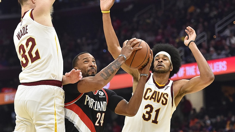 Nov 3, 2021; Cleveland, Ohio, USA; Portland Trail Blazers forward Norman Powell (24) drives between Cleveland Cavaliers forward Dean Wade (32) and center Jarrett Allen (31) in the second quarter at Rocket Mortgage FieldHouse. Mandatory Credit: David Richard-USA TODAY Sports