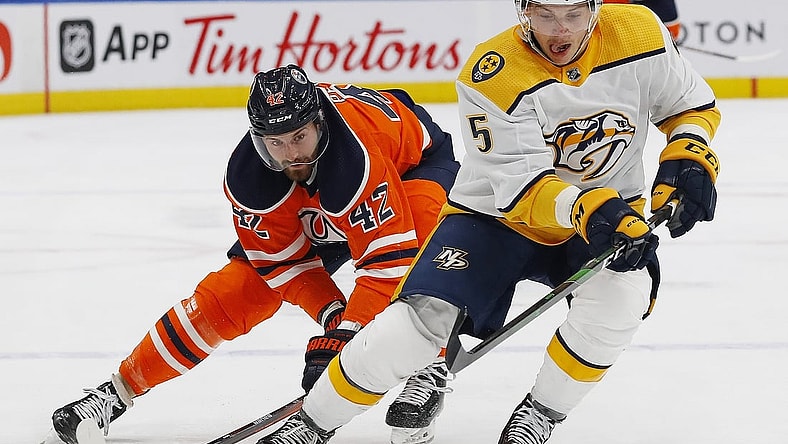 Nov 3, 2021; Edmonton, Alberta, CAN; Nashville Predators defensemen Matt Benning (5) moves the puck in front of Edmonton Oilers forward Brendan Perlini (42) during the first period at Rogers Place. Mandatory Credit: Perry Nelson-USA TODAY Sports