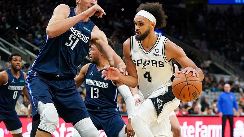 Nov 3, 2021; San Antonio, Texas, USA;  San Antonio Spurs guard Derrick White (4) dribbles against Dallas Mavericks center Boban Marjanovic (51) in the first half at the AT&T Center. Mandatory Credit: Daniel Dunn-USA TODAY Sports