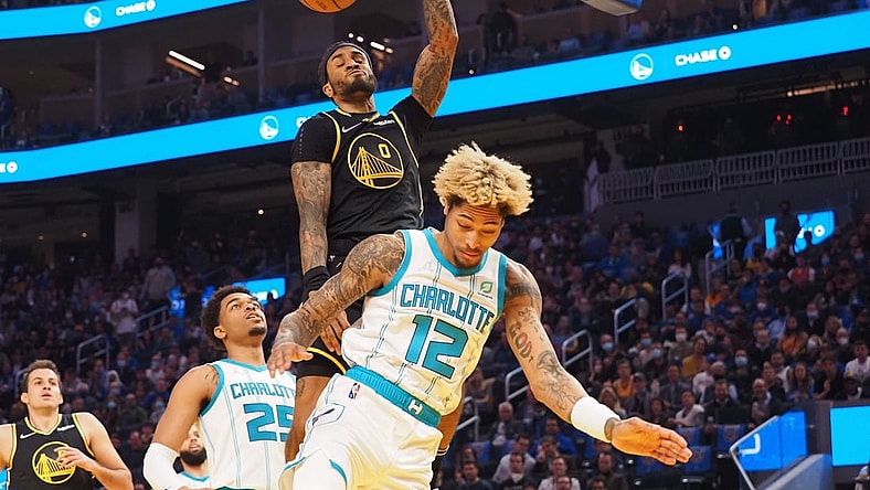Nov 3, 2021; San Francisco, California, USA; Golden State Warriors guard Gary Payton II (0) dunks the ball above Charlotte Hornets forward-guard Kelly Oubre Jr. (12) during the first quarter at Chase Center. Mandatory Credit: Kelley L Cox-USA TODAY Sports