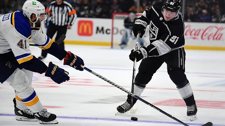 Nov 3, 2021; Los Angeles, California, USA; Los Angeles Kings left wing Carl Grundstrom (91) shoots against the defense of St. Louis Blues defenseman Robert Bortuzzo (41) during the second period at Staples Center. Mandatory Credit: Gary A. Vasquez-USA TODAY Sports