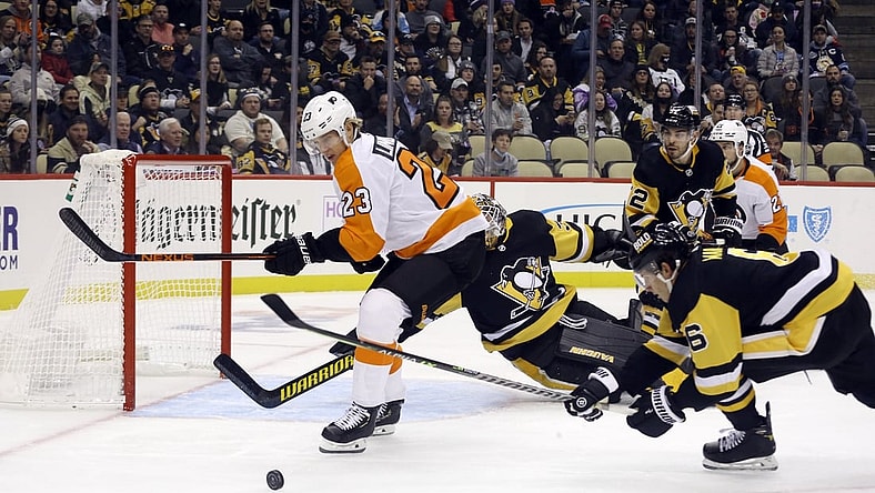 Nov 4, 2021; Pittsburgh, Pennsylvania, USA; Philadelphia Flyers left wing Oskar Lindblom (23) and Pittsburgh Penguins defenseman John Marino (6) chase the puck in front of Penguins goaltender Tristan Jarry (35) during the first period at PPG Paints Arena. Mandatory Credit: Charles LeClaire-USA TODAY Sports