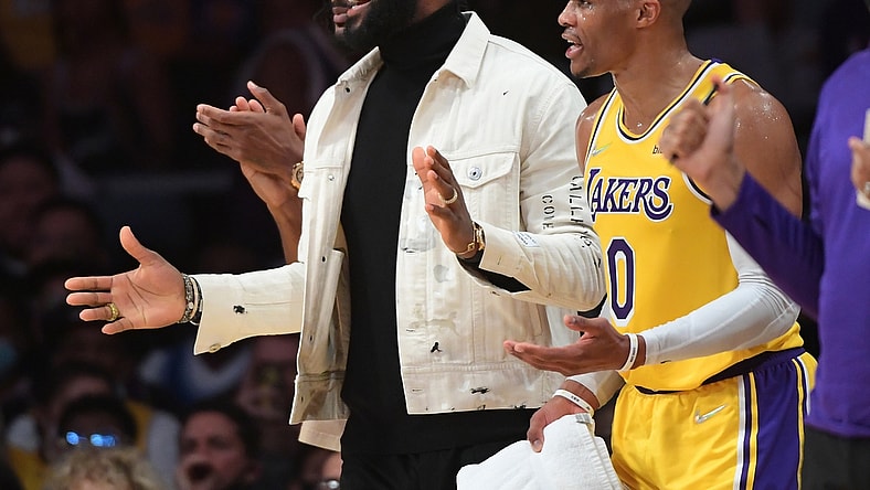 Nov 4, 2021; Los Angeles, California, USA; Los Angeles Lakers forward LeBron James (center) and guard Russell Westbrook (0) look on from the bench during the game against the Oklahoma City Thunder at Staples Center. Mandatory Credit: Jayne Kamin-Oncea-USA TODAY Sports