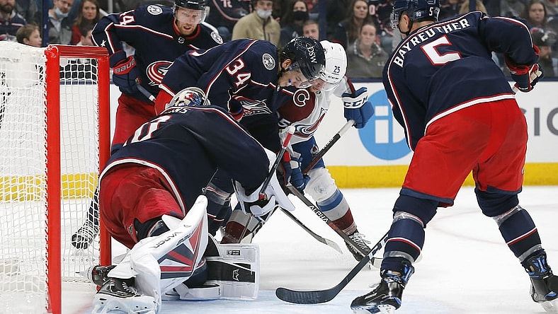 Nov 6, 2021; Columbus, Ohio, USA; Columbus Blue Jackets center Cole Sillinger (34) and Colorado Avalanche right wing Logan O'Connor (25) battle for a loose puck during the third period at Nationwide Arena. Mandatory Credit: Russell LaBounty-USA TODAY Sports