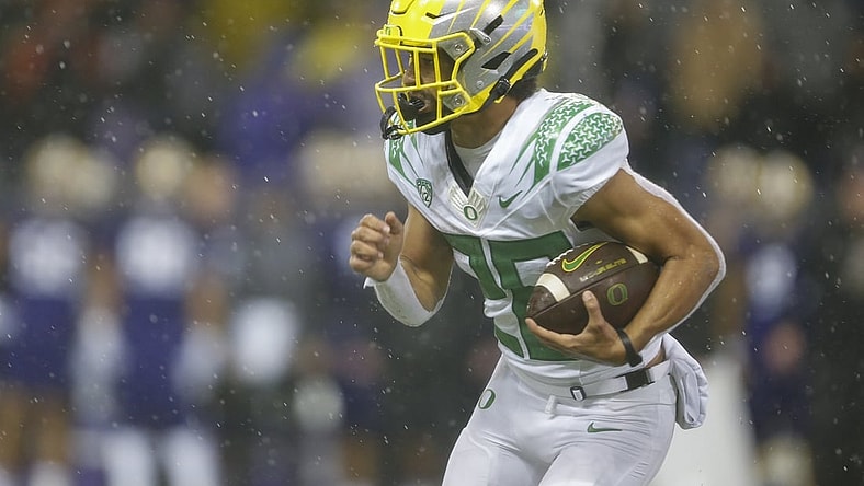 Nov 6, 2021; Seattle, Washington, USA; Oregon Ducks running back Travis Dye (26) rushes against the Washington Huskies during the second quarter at Alaska Airlines Field at Husky Stadium. Mandatory Credit: Joe Nicholson-USA TODAY Sports
