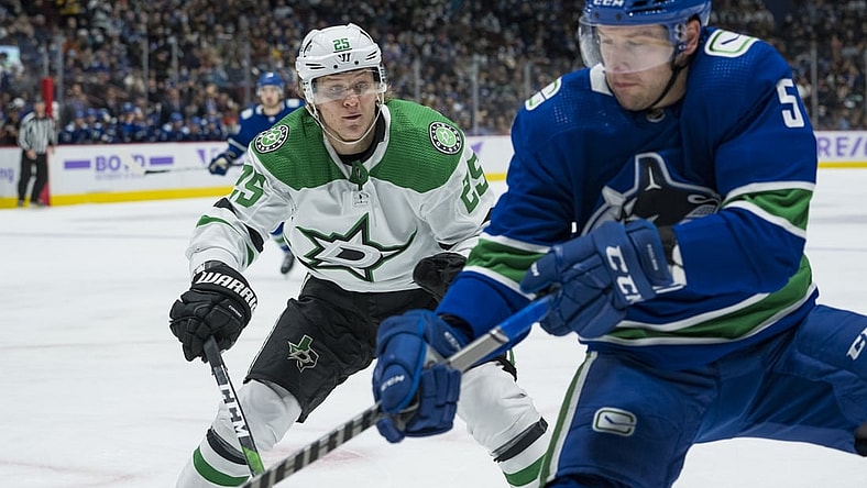 Nov 7, 2021; Vancouver, British Columbia, CAN;Dallas Stars forward Joel Kiviranta (25) checks Vancouver Canucks defenseman Tucker Poolman (5) in the second period at Rogers Arena. Mandatory Credit: Bob Frid-USA TODAY Sports