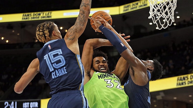 Nov 8, 2021; Memphis, Tennessee, USA; Minnesota Timberwolves center/forward Karl-Anthony Towns (32) fights for control of a rebound with Memphis Grizzles forward Jaren Jackson Jr. (13) during the first half at FedExForum. Mandatory Credit: Petre Thomas-USA TODAY Sports