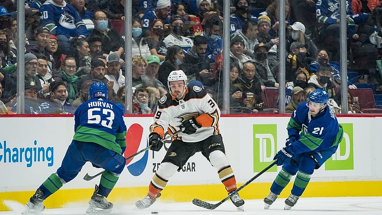 Nov 9, 2021; Vancouver, British Columbia, CAN; Vancouver Canucks forward Bo Horvat (53) and forward Nils Hoglander (21) check Anaheim Ducks forward Sam Carrick (39) in the second period at Rogers Arena. Mandatory Credit: Bob Frid-USA TODAY Sports