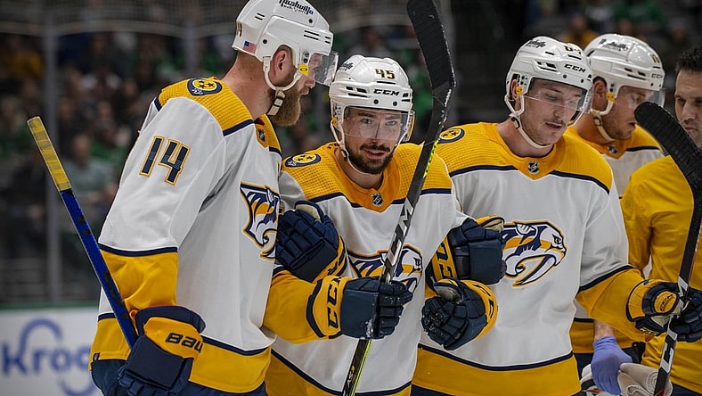 Nov 10, 2021; Dallas, Texas, USA; Nashville Predators defenseman Alexandre Carrier (45) is helped off the ice by defenseman Mattias Ekholm (14) and center Mikael Granlund (64) during the second period against the Dallas Stars at the American Airlines Center. Mandatory Credit: Jerome Miron-USA TODAY Sports