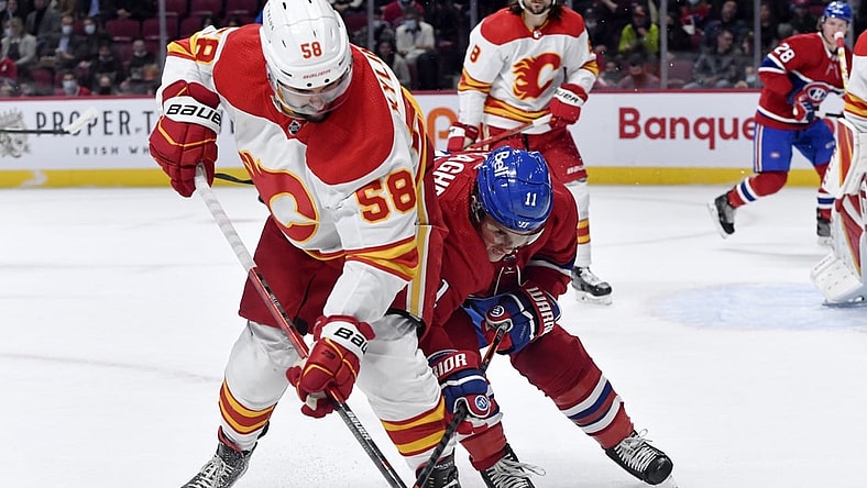 Nov 11, 2021; Montreal, Quebec, CAN; Calgary Flames defenseman Oliver Kylington (58) and Montreal Canadiens forward Brendan Gallagher (11) battle for the puck during the first period at the Bell Centre. Mandatory Credit: Eric Bolte-USA TODAY Sports