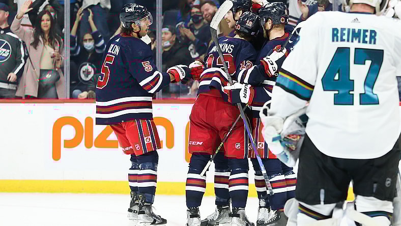 Nov 11, 2021; Winnipeg, Manitoba, CAN;  Winnipeg Jets forward Jansen Harkins (12) is congratulated by his teammates on his goal against the San Jose Sharks during the second period at Canada Life Centre. Mandatory Credit: Terrence Lee-USA TODAY Sports