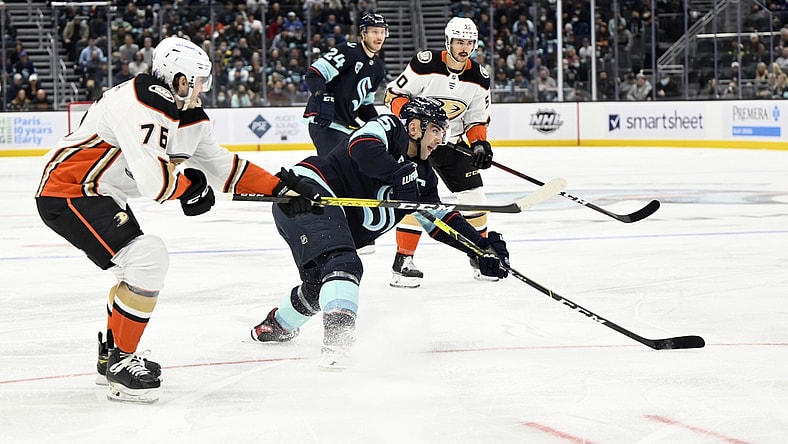 Nov 11, 2021; Seattle, Washington, USA; Seattle Kraken defenseman Mark Giordano (5) clears the puck while being defended by Anaheim Ducks defenseman Josh Mahura (76) during the first period at Climate Pledge Arena. Mandatory Credit: Steven Bisig-USA TODAY Sports