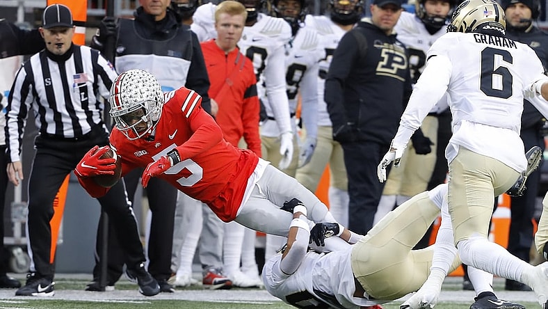 Nov 13, 2021; Columbus, Ohio, USA; Ohio State Buckeyes wide receiver Garrett Wilson (5) dives for the first down as he is tackled by Purdue Boilermakers safety Cam Allen (10) during the first quarter at Ohio Stadium. Mandatory Credit: Joseph Maiorana-USA TODAY Sports