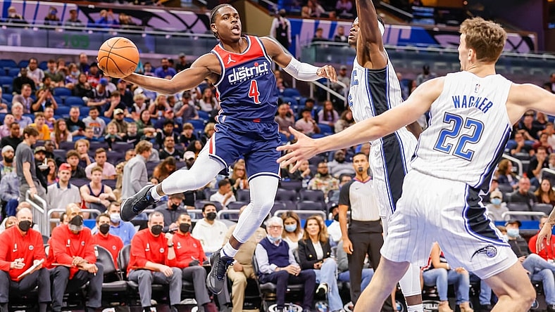 Nov 13, 2021; Orlando, Florida, USA; Washington Wizards guard Aaron Holiday (4) passes the ball in front of Orlando Magic center Mo Bamba (center) and forward Franz Wagner (22) during the first quarter at Amway Center. Mandatory Credit: Mike Watters-USA TODAY Sports