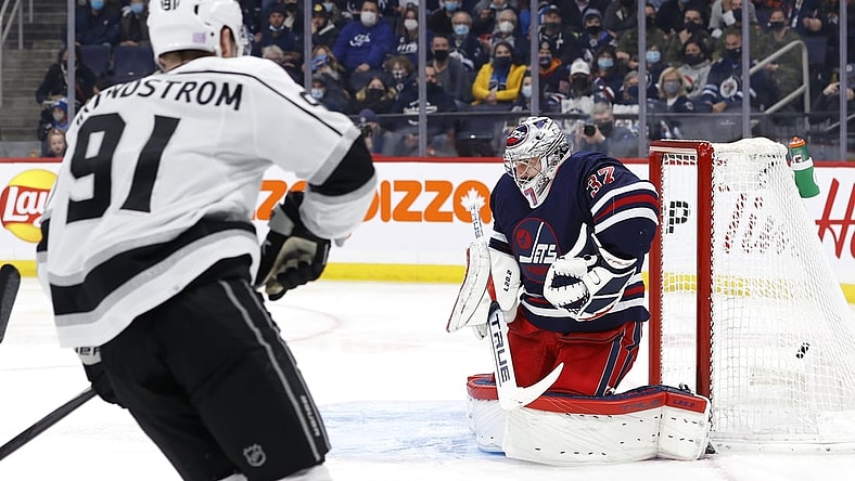 Nov 13, 2021; Winnipeg, Manitoba, CAN; Los Angeles Kings left wing Carl Grundstrom (91) scores a goal on Winnipeg Jets goaltender Connor Hellebuyck (37) in the first period at Canada Life Centre. Mandatory Credit: James Carey Lauder-USA TODAY Sports