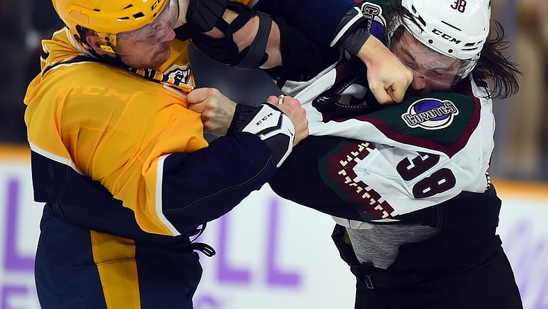 Nov 13, 2021; Nashville, Tennessee, USA; Arizona Coyotes center Liam 0'Brien (38) and Nashville Predators right wing Mathieu Olivier (25) fight during the first period at Bridgestone Arena. Mandatory Credit: Christopher Hanewinckel-USA TODAY Sports