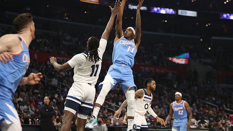 Nov 13, 2021; Los Angeles, California, USA; Los Angeles Clippers guard Terance Mann (14) shoots the ball over Minnesota Timberwolves center Naz Reid (11) during the second quarter at Staples Center. Mandatory Credit: Kiyoshi Mio-USA TODAY Sports