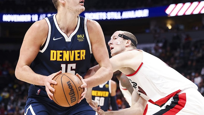 Nov 14, 2021; Denver, Colorado, USA; Denver Nuggets center Nikola Jokic (15) goes up for a shot over Portland Trail Blazers center Cody Zeller (40) in the first quarter at Ball Arena. Mandatory Credit: Michael Ciaglo-USA TODAY Sports