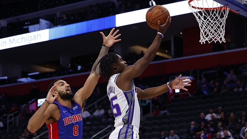 Nov 15, 2021; Detroit, Michigan, USA;  Sacramento Kings guard Davion Mitchell (15) goes to the basket on Detroit Pistons forward Trey Lyles (8) in the first half at Little Caesars Arena. Mandatory Credit: Rick Osentoski-USA TODAY Sports