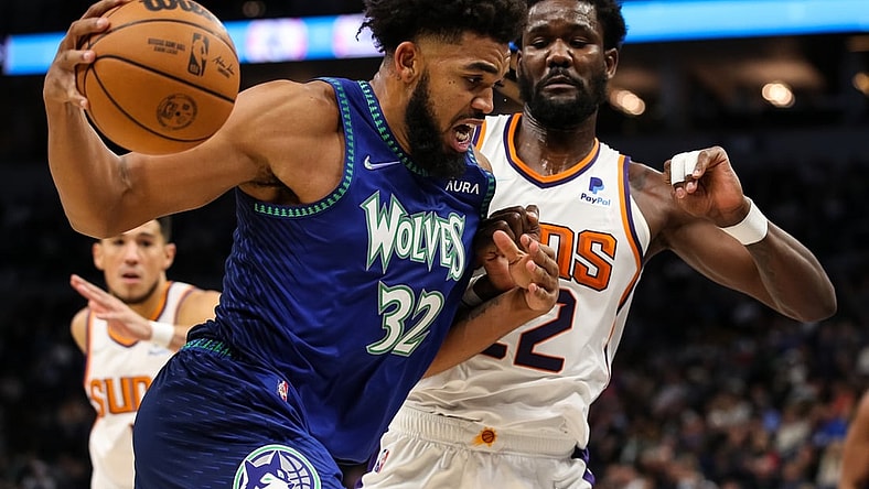 Nov 15, 2021; Minneapolis, Minnesota, USA; Minnesota Timberwolves center Karl-Anthony Towns (32) drives to the basket while Phoenix Suns center Deandre Ayton (22) defends in the first half at Target Center. Mandatory Credit: David Berding-USA TODAY Sports