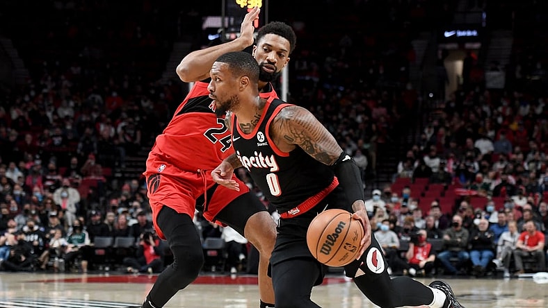 Nov 15, 2021; Portland, Oregon, USA; Portland Trail Blazers guard Damian Lillard (0) drives to the basket on Portland Trail Blazers forward Norman Powell (24) during the first quarter  the game at Moda Center. Mandatory Credit: Steve Dykes-USA TODAY Sports