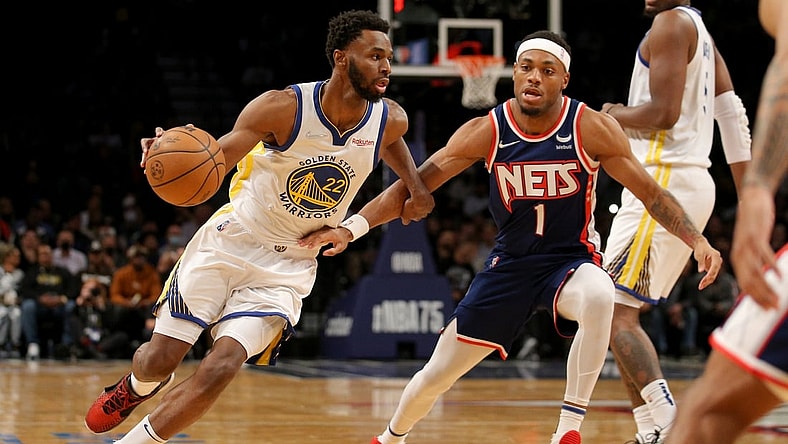 Nov 16, 2021; Brooklyn, New York, USA; Golden State Warriors forward Andrew Wiggins (22) drives around Brooklyn Nets forward Bruce Brown (1) during the first quarter at Barclays Center. Mandatory Credit: Brad Penner-USA TODAY Sports