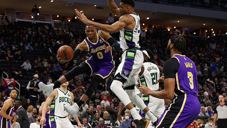 Nov 17, 2021; Milwaukee, Wisconsin, USA;  Los Angeles Lakers guard Russell Westbrook (0) passes the ball around Milwaukee Bucks forward Giannis Antetokounmpo (34) during the first quarter at Fiserv Forum. Mandatory Credit: Jeff Hanisch-USA TODAY Sports